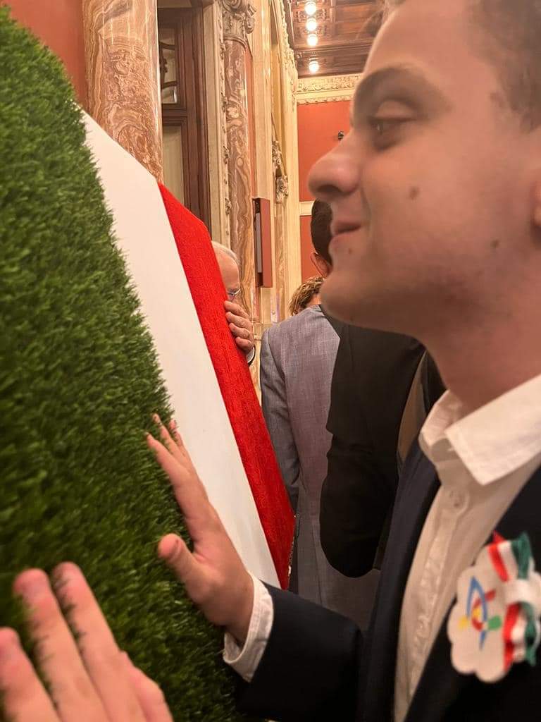 Un ragazzo non vedente ammira la bandiera italiana realizzata per celebrare i 75 anni dall'entrata in vigore della Costituzione Italiana.