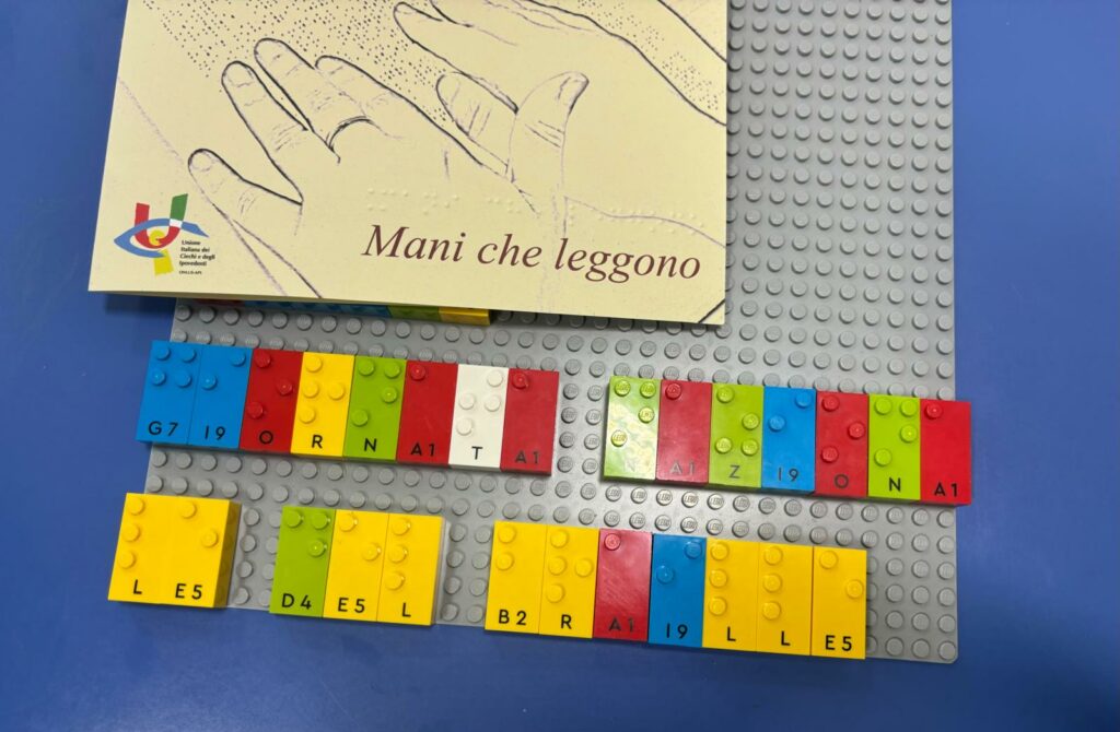 L'immagine raffigura l'utilizzo dei Lego Braille Bricks comporre la frase "Giornata nazionale del Braille". 
